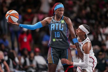 Jun 20, 2025; College Park, Georgia, USA; Atlanta Dream guard Rhyne Howard (10) protects the ball from Washington Mystics guard Brittney Sykes (20) during the first half at Gateway Center Arena at College Park. Mandatory Credit: Dale Zanine-Imagn Images