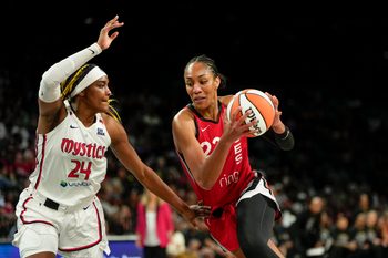 Jun 26, 2025; Las Vegas, Nevada, USA;  Las Vegas center A'ja Wilson (22) drives the ball against Washington Mystics forward Aaliyah Edwards (24) during the first half of a WNBA basketball game at Michelob Ultra Arena. Mandatory Credit: Lucas Peltier-Imagn Images