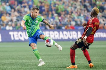 Aug 20, 2023; Seattle, Washington, USA; Seattle Sounders FC midfielder Albert Rusnak (11) shoots a deflection before Atlanta United midfielder Edwin Mosquera (21) can reach it during the second half at Lumen Field. Mandatory Credit: Joe Nicholson-Imagn Images