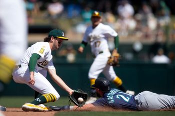 May 7, 2025; West Sacramento, California, USA; Seattle Mariners pinch runner Miles Mastrobuoni (21) slides safely into second with a stolen base ahead of the throw to Athletics shortstop Jacob Wilson (5) during the eighth inning at Sutter Health Park. Mandatory Credit: D. Ross Cameron-Imagn Images