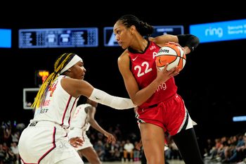 Jun 26, 2025; Las Vegas, Nevada, USA; Las Vegas Aces center A'ja Wilson (22) controls the ball against Washington Mystics forward Aaliyah Edwards (24) during the first half of a WNBA basketball game at Michelob Ultra Arena. Mandatory Credit: Lucas Peltier-Imagn Images