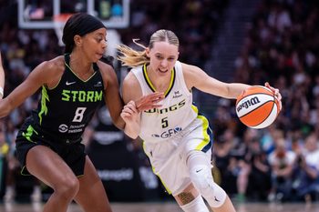 Jul 22, 2025; Seattle, Washington, USA;  Dallas Wings guard Paige Bueckers (5) dribbles the ball against Seattle Storm guard Lexie Brown (8) during the second half at Climate Pledge Arena. Mandatory Credit: Stephen Brashear-Imagn Images