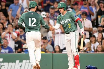 Jul 25, 2025; Boston, Massachusetts, USA; Boston Red Sox catcher Connor Wong (12) high-fives third baseman Alex Bregman (2) after scoring a run against the Los Angeles Dodgers during the third inning at Fenway Park. Mandatory Credit: Brian Fluharty-Imagn Images
