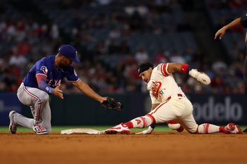 Jul 29, 2025; Anaheim, California, USA;  Los Angeles Angels right fielder Gustavo Campero (51) is tagged out by Texas Rangers second baseman Marcus Semien (2) as he tries to steal second during the fourth inning at Angel Stadium. Mandatory Credit: Kiyoshi Mio-Imagn Images
