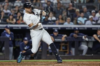 Jul 30, 2025; Bronx, New York, USA;  New York Yankees designated hitter Giancarlo Stanton (27) hits an RBI single in the eighth inning against the Tampa Bay Rays at Yankee Stadium. Mandatory Credit: Wendell Cruz-Imagn Images