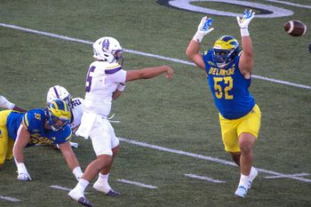 Albany quarterback Myles Burkett throws as Delaware's Melkart Abou-Jaoude (left) and Dominick Brogna close in during the third quarter of the Blue Hens' 28-14 win at Delaware Stadium, Saturday, Oct. 26, 2024.