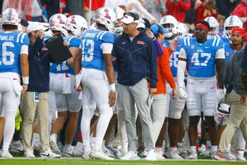 Nov 9, 2024; Oxford, Mississippi, USA; Mississippi Rebels head coach Lane Kiffin talks with quarterback Austin Simmons (13) after a touchdown during the first half against the Georgia Bulldogs at Vaught-Hemingway Stadium. Mandatory Credit: Petre Thomas-Imagn Images