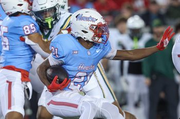 Nov 23, 2024; Houston, Texas, USA; Houston Cougars running back Stacy Sneed (21) runs with the ball during the second quarter against the Baylor Bears at TDECU Stadium. Mandatory Credit: Troy Taormina-Imagn Images