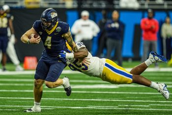 Toledo Rockets quarterback Tucker Gleason (4) avoids being tackled by Pittsburgh Panthers defensive lineman Francis Brewu (95), during one of the six overtimes in the 2024 GameAbove Sports Bowl at Ford Field in Detroit, on Thursday, Dec. 26, 2024.