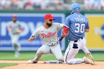 Mar 29, 2025; Washington, District of Columbia, USA; Philadelphia Phillies shortstop Edmundo Sosa (33) tops the ball as Washington Nationals outfielder Jacob Young (30) slides into second base during the eighth inning at Nationals Park. Mandatory Credit: Reggie Hildred-Imagn Images