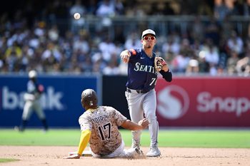 May 18, 2025; San Diego, California, USA; Seattle Mariners second baseman Leo Rivas (76) throws over San Diego Padres catcher Elias Diaz (17) as he turns a double play during the eighth inning at Petco Park. Mandatory Credit: Denis Poroy-Imagn Images