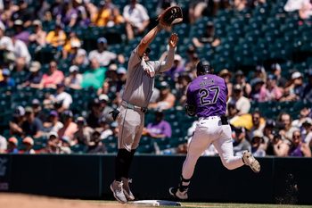 Jun 22, 2025; Denver, Colorado, USA; Arizona Diamondbacks catcher Jose Herrera (11) is unable to field an over thrown ball as Colorado Rockies left fielder Jordan Beck (27) reaches first in the fourth inning at Coors Field. Mandatory Credit: Isaiah J. Downing-Imagn Images