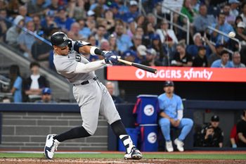 Jul 23, 2025; Toronto, Ontario, CAN;  New York Yankees designated hitter Aaron Judge (99) hits a two run home run against the Toronto Blue Jays in the sixth inning at Rogers Centre. Mandatory Credit: Dan Hamilton-Imagn Images