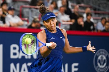 Aug 6, 2025; Montreal, QC, Canada; Naomi Osaka (JPN) returns the ball to Clara Tauson (DEN) in semifinal play at IGA Stadium. Mandatory Credit: David Kirouac-Imagn Images