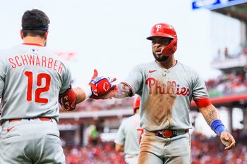 Aug 11, 2025; Cincinnati, Ohio, USA; Philadelphia Phillies second baseman Edmundo Sosa (33) high fives designated hitter Kyle Schwarber (12) after scoring on a double hit by outfielder Weston Wilson (not pictured) in the eighth inning against the Cincinnati Reds at Great American Ball Park. Mandatory Credit: Katie Stratman-Imagn Images