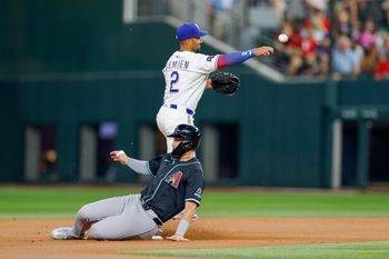 Aug 12, 2025; Arlington, Texas, USA; Texas Rangers second baseman Marcus Semien (2) plays a ground ball with Arizona Diamondbacks first baseman Tyler Locklear (28) sliding into second base during the second inning at Globe Life Field. Mandatory Credit: Andrew Dieb-Imagn Images