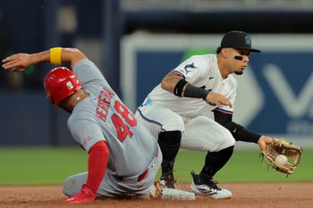Aug 18, 2025; Miami, Florida, USA; St. Louis Cardinals designated hitter Ivan Herrera (48) slides back into second base against Miami Marlins second baseman Maximo Acosta (24) during the first inning at loanDepot Park. Mandatory Credit: Sam Navarro-Imagn Images