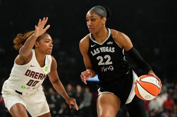Aug 19, 2025; Las Vegas, Nevada, USA; Las Vegas Aces center A'ja Wilson (22) drives the ball past Atlanta Dream forward Naz Hillmon (00) during the first half of a WNBA basketball game at Michelob Ultra Arena. Mandatory Credit: Lucas Peltier-Imagn Images