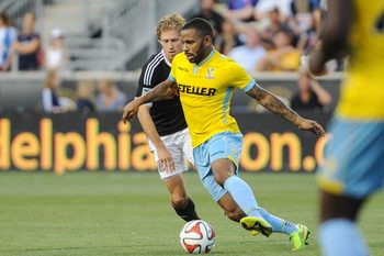Jul 25, 2014; Chester, PA, USA; Crystal Palace midfielder Jason Puncheon (13) moves the ball as Crystal Palace midfielder Yannick Bolasie (7) defends during the second half of the match at PPL Park. Crystal Palace FC won the match 1-0. Mandatory Credit: John Geliebter-Imagn Images