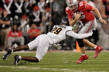 Sep 17, 2022; Columbus, Ohio, USA; Ohio State Buckeyes quarterback Devin Brown (15) is tackled by Toledo Rockets cornerback Nick Turner (29) during a college football game at Ohio Stadium. Mandatory Credit: Barbara Perenic-Imagn Images