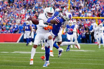 Nov 3, 2024; Orchard Park, New York, USA; Miami Dolphins safety Jordan Poyer (21) separates Buffalo Bills wide receiver Keon Coleman (0) from the ball to break up a pass during the second half at Highmark Stadium. Mandatory Credit: Gregory Fisher-Imagn Images
