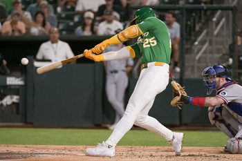 Aug 29, 2025; West Sacramento, California, USA; Athletics outfielder Brent Rooker (25) hits an rbi double against the Texas Rangers during the third inning at Sutter Health Park. Mandatory Credit: Ed Szczepanski-Imagn Images