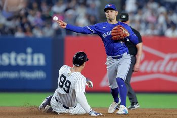 Sep 5, 2025; Bronx, New York, USA; Toronto Blue Jays second baseman Andres Gimenez (0) forces out New York Yankees right fielder Aaron Judge (99) at second base and throws to first to complete a game ending double play on a ball hit by designated hitter Giancarlo Stanton (not pictured) during the ninth inning at Yankee Stadium. Mandatory Credit: Brad Penner-Imagn Images