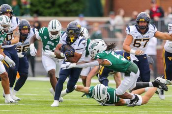 Sep 6, 2025; Athens, Ohio, USA; West Virginia Mountaineers running back Jahiem White (1) runs the ball and is tackled by Ohio Bobcats safety Adonis Williams Jr. (5) during the first quarter at Peden Stadium. Mandatory Credit: Ben Queen-Imagn Images