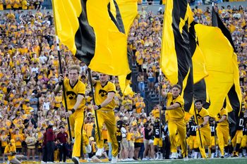 The Iowa Hawkeyes spirit squard runs flags across the field as the players swarm onto the field ahead of the football game against the Massachusetts Minutemen Sept. 13, 2025 at Kinnick Stadium in Iowa City, Iowa.