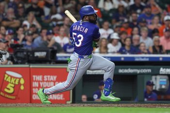 Sep 16, 2025; Houston, Texas, USA; Texas Rangers pinch hitter Adolis Garcia hits an RBI single during the eighth inning against the Houston Astros at Daikin Park. Mandatory Credit: Troy Taormina-Imagn Images