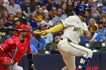 Sep 17, 2025; Milwaukee, Wisconsin, USA; Milwaukee Brewers center fielder Blake Perkins (16) drives in two runs with a base hit as Los Angeles Angels catcher Sebastian Rivero (38) watches in the second inning at American Family Field. Mandatory Credit: Benny Sieu-Imagn Images