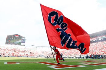 Sep 20, 2025; Oxford, Mississippi, USA; Mississippi Rebels cheerleader run an Ole Miss flag through the end zone after a touchdown during the fourth quarter against the Tulane Green Wave at Vaught-Hemingway Stadium. Mandatory Credit: Petre Thomas-Imagn Images
