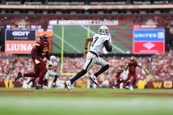 Sep 21, 2025; Landover, Maryland, USA; Las Vegas Raiders quarterback Geno Smith (7) scrambles from Washington Commanders defensive end Javontae Jean-Baptiste (90) during the fourth quarter at Northwest Stadium. Mandatory Credit: Geoff Burke-Imagn Images