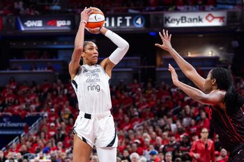 Sep 28, 2025; Indianapolis, Indiana, USA; Las Vegas Aces center A'ja Wilson (22) shoots the ball while Indiana Fever forward Aliyah Boston (7) defends in the second half  during game four of the second round for the 2025 WNBA Playoffs at Gainbridge Fieldhouse. Mandatory Credit: Trevor Ruszkowski-Imagn Images