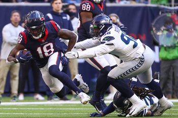 Dec 12, 2021; Houston, Texas, USA; Houston Texans wide receiver Chris Conley (18) makes a reception during the fourth quarter as Seattle Seahawks outside linebacker Alton Robinson (98) defends during the fourth quarter at NRG Stadium. Mandatory Credit: Troy Taormina-Imagn Images