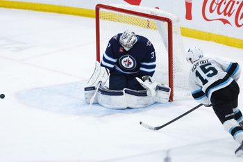 Jan 24, 2025; Winnipeg, Manitoba, CAN; Winnipeg Jets goalie Connor Hellebuyck (37) makes a save on a shot by Utah Hockey Club forward Alexander Kerfoot (15) during the third period at Canada Life Centre. Mandatory Credit: Terrence Lee-Imagn Images