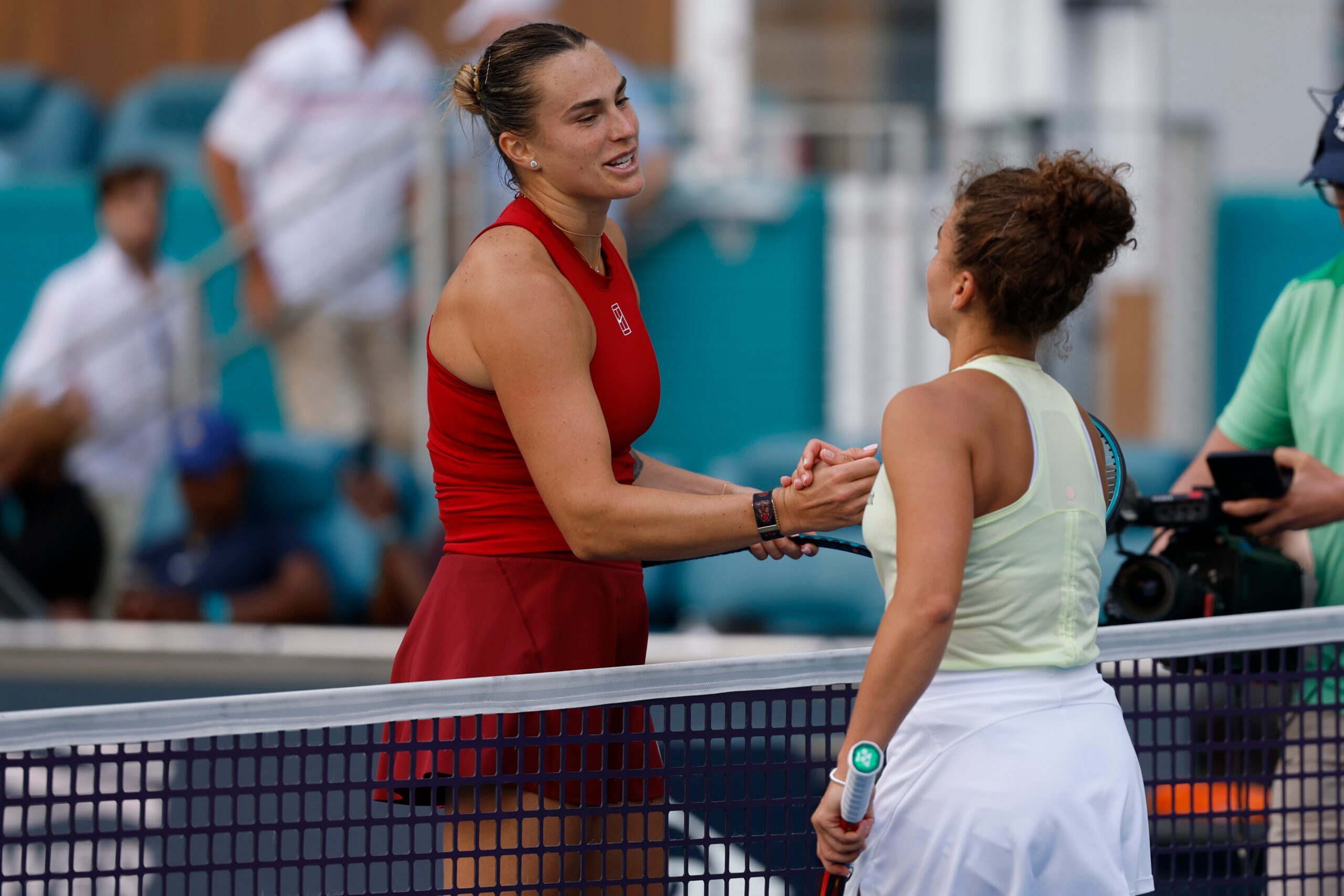 Mar 27, 2025; Miami, FL, USA; Aryna Sabalenka (L) shakes hands with Jasmine Paolini (ITA)(R) at the net after their women's singles semifinal on day ten of the Miami Open at Hard Rock Stadium. Mandatory Credit: Geoff Burke-Imagn Images