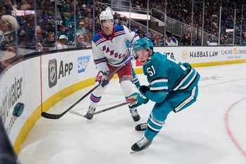 Mar 29, 2025; San Jose, California, USA; New York Rangers defenseman Braden Schneider (4) passes the puck against San Jose Sharks right wing Collin Graf (51) during the second period at SAP Center at San Jose. Mandatory Credit: Robert Edwards-Imagn Images