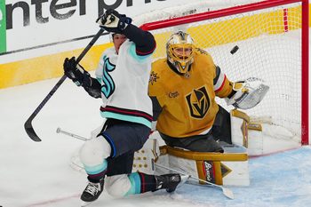 Apr 10, 2025; Las Vegas, Nevada, USA; Vegas Golden Knights goaltender Adin Hill (33) watches a loose puck behind Seattle Kraken defenseman Brandon Montour (62) during the third period at T-Mobile Arena. Mandatory Credit: Stephen R. Sylvanie-Imagn Images