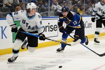 Apr 15, 2025; St. Louis, Missouri, USA; St. Louis Blues right wing Alexey Toropchenko (13) pressures Utah Hockey Club center Logan Cooley (92) during the second period at Enterprise Center. Mandatory Credit: Jeff Le-Imagn Images