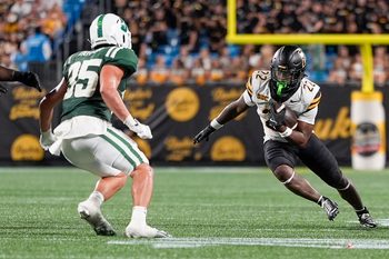 Aug 29, 2025; Charlotte, North Carolina, USA; Appalachian State Mountaineers running back Jaquari Lewis (22) tries to elude Charlotte 49ers linebacker Shay Taylor (35) during the second half at Bank of America Stadium. Mandatory Credit: Jim Dedmon-Imagn Images