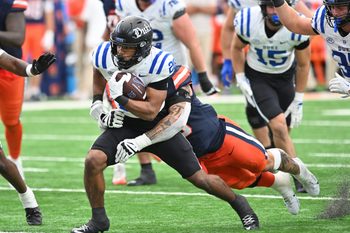 Sep 27, 2025; Syracuse, New York, USA; Duke Blue Devils running back Nate Sheppard (20) tries to break a tackle by Syracuse Orange defensive lineman Nathan Nyandoro (30) in the fourth quarter at the JMA Wireless Dome. Mandatory Credit: Mark Konezny-Imagn Images