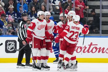 Oct 2, 2025; Toronto, Ontario, CAN; Detroit Red Wings center Dylan Larkin (71) scores a goal and celebrates with defenseman Ben Chiarot (8) against the Toronto Maple Leafs during the third period at Scotiabank Arena. Mandatory Credit: Nick Turchiaro-Imagn Images