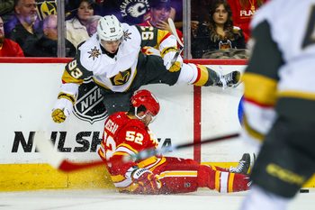 Oct 14, 2025; Calgary, Alberta, CAN; Calgary Flames defenseman Mackenzie Weegar (52) and Vegas Golden Knights right wing Mitch Marner (93) battles for the puck during the third period at Scotiabank Saddledome. Mandatory Credit: Sergei Belski-Imagn Images