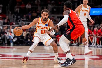 Oct 16, 2025; Atlanta, Georgia, USA; Atlanta Hawks point guard Trae Young (11) dribbles against Houston Rockets guard Aaron Holiday (0) during the first half at State Farm Arena. Mandatory Credit: Dale Zanine-Imagn Images