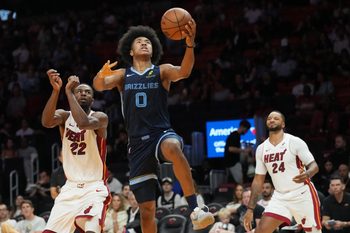 Oct 17, 2025; Miami, Florida, USA;  Memphis Grizzlies guard Jaylen Wells (0) drives to the basket as Miami Heat forward Andrew Wiggins (22) and guard Norman Powell (24) look on during the second half at Kaseya Center. Mandatory Credit: Jim Rassol-Imagn Images