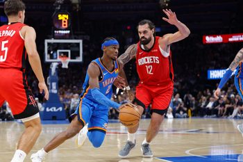 Oct 21, 2025; Oklahoma City, Oklahoma, USA; Oklahoma City Thunder guard Shai Gilgeous-Alexander (2) drives to the basket beside Houston Rockets center Steven Adams (12) during the first half at Paycom Center. Mandatory Credit: Alonzo Adams-Imagn Images