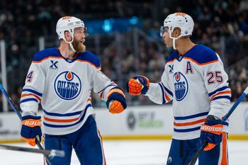 Oct 25, 2025; Seattle, Washington, USA; Edmonton Oilers defenseman Mattias Ekholm (14) and defenseman Darnell Nurse (25) celebrate after a goal during the third period against the Seattle Kraken at Climate Pledge Arena. Mandatory Credit: Stephen Brashear-Imagn Images