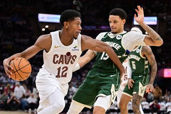 Oct 26, 2025; Cleveland, Ohio, USA; Cleveland Cavaliers guard De'Andre Hunter (12) drives to the basket against Milwaukee Bucks guard Ryan Rollins (13) during the second half at Rocket Arena. Mandatory Credit: Ken Blaze-Imagn Images