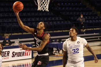 Mar 5, 2021; Richmond, Virginia, USA; Massachusetts Minutemen guard Cairo McCrory (5) shoots the ball as Saint Louis Billikens forward Jimmy Bell Jr. (32) looks on in the first half of a quarterfinal in the Atlantic 10 conference tournament at Robins Center. Mandatory Credit: Geoff Burke-Imagn Images